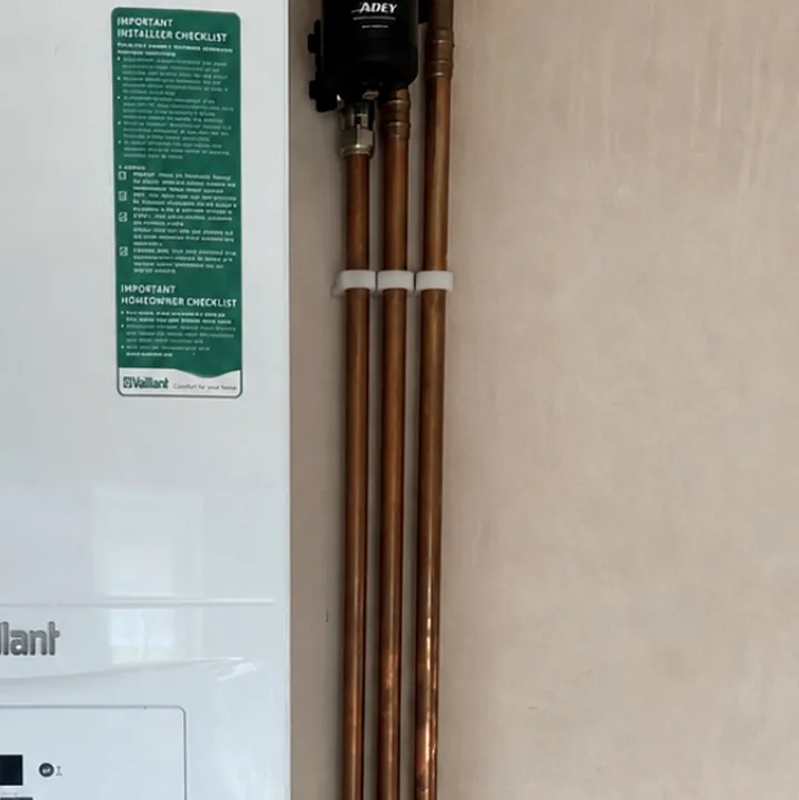 Vertical copper pipe run beside a new boiler