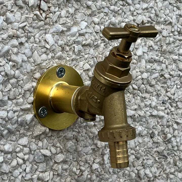 New brass outside tap on a wall plate with a hose union