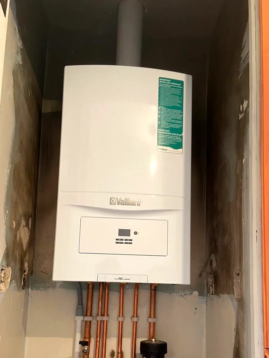 Boiler installed in a cupboard with a flue and copper tails
