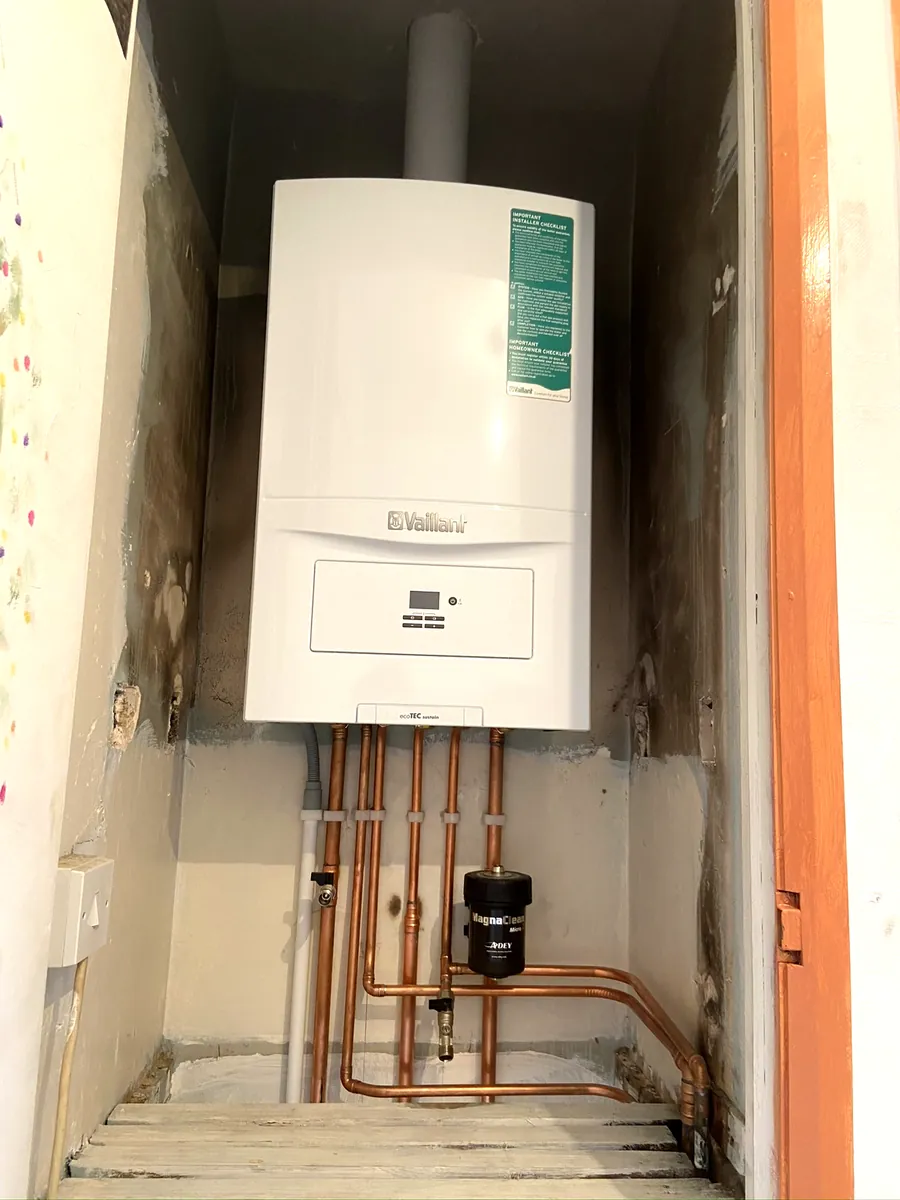 Boiler and copper pipework in a narrow cupboard